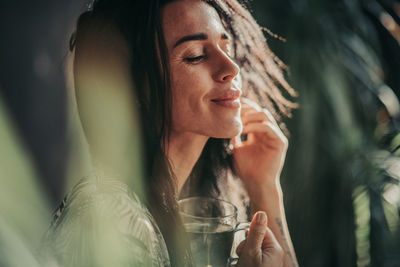 Portrait of a smiling young woman drinking glass