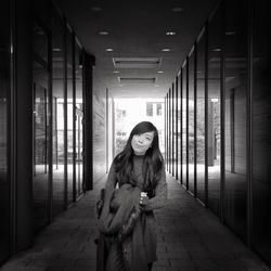 Portrait of a young woman standing on wall