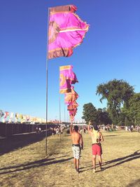 Rear view of man looking at flags on field during music festival