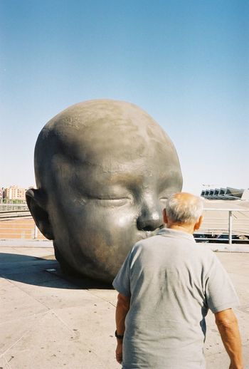 REAR VIEW OF MAN AGAINST THE SKY