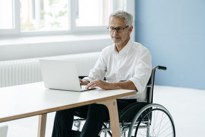 Handicapped manager in a wheelchair, working in office