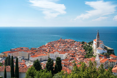 High angle view of townscape by sea against sky