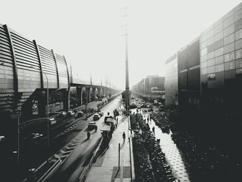 Railroad tracks in city against clear sky