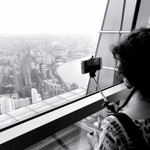 Rear view of woman photographing cityscape