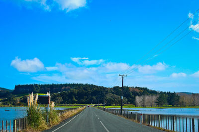 Empty road against blue sky