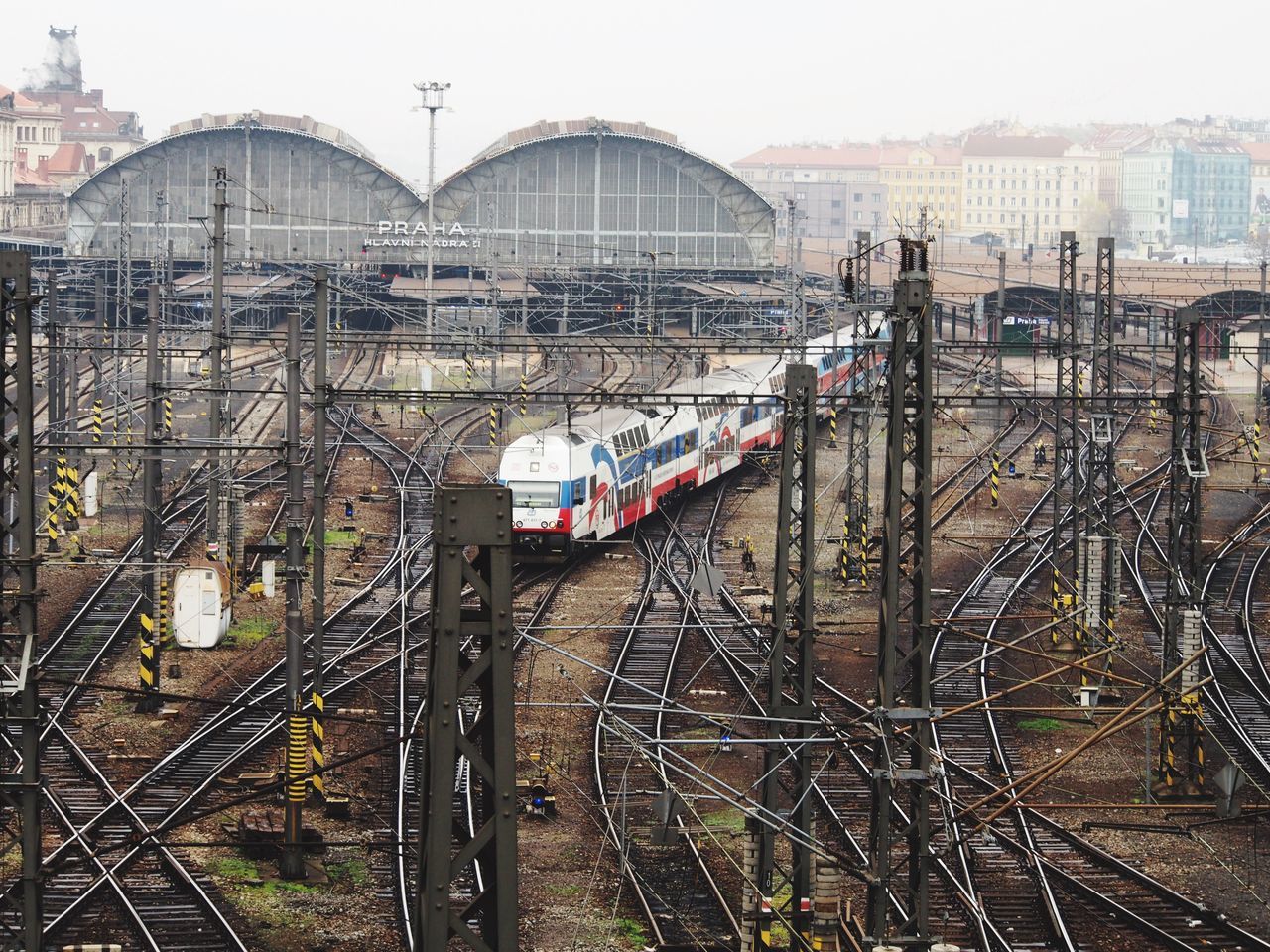 architecture, built structure, transportation, building exterior, city, railroad track, land vehicle, mode of transport, car, clear sky, travel, rail transportation, road, day, bridge - man made structure, public transportation, city life, incidental people, high angle view, outdoors