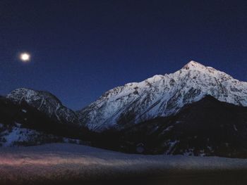 Scenic view of snowcapped mountains against sky at night