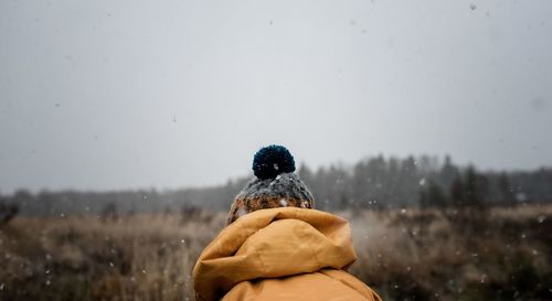 The back of a bobble hat on a child playing outside in the snow