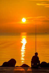 Scenic view of sea against orange sky