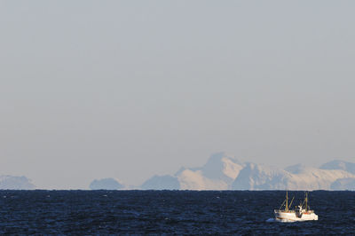 Boat on sea, iceberg on background