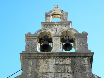 Low angle view of bell tower against blue sky