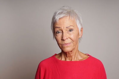 Portrait of senior woman against gray background