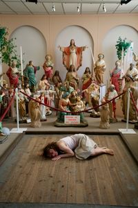 Statue of woman lying down on floor