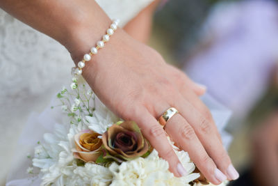 Cropped image of bride touching bouquet