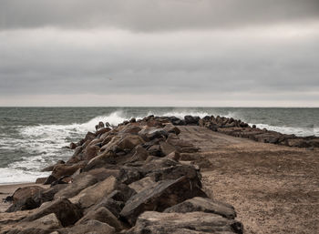 Scenic view of rocks on beach against sky