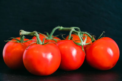 Close-up of tomatoes on table against black background