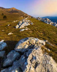 Scenic view of rocks by sea against sky