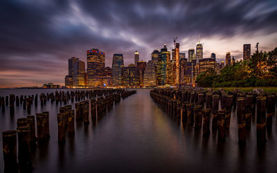 Panoramic view of sea and buildings against sky at sunset