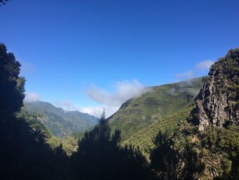 Scenic view of mountains against blue sky