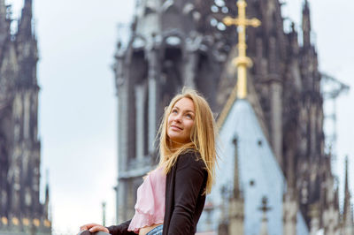 Side view of woman standing against cologne cathedral