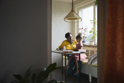 Mother and daughter sitting together at table