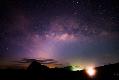 Scenic view of silhouette mountains against sky at night