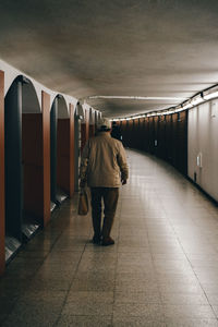 Rear view of man walking in subway