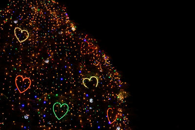 Low angle view of illuminated lights against sky at night