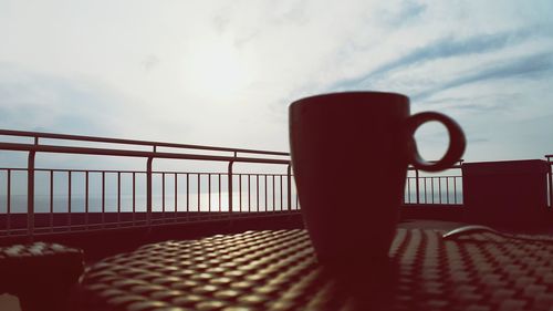 Close-up of coffee cup on table against sky