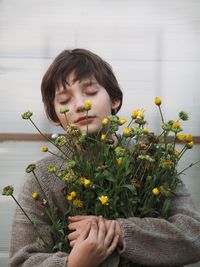 Boy holding potted plant