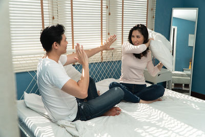 Side view of young couple sitting in corridor