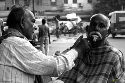 Portrait of man with people in city