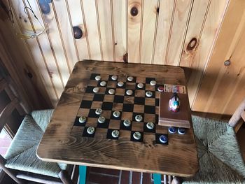 High angle view of chess pieces on hardwood floor