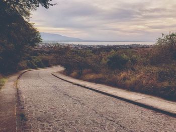 Road amidst trees against sky