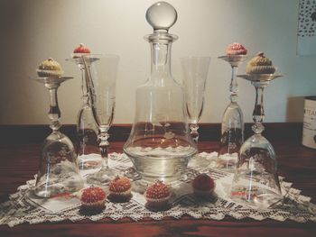 Close-up of wine bottles on table against wall