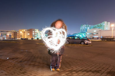 Man standing in front of illuminated city at night