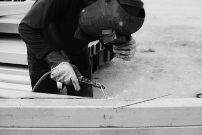 Manual worker welding with tool outdoor