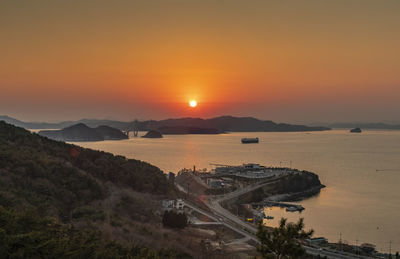 High angle view of sea against orange sky