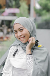 Portrait of smiling young woman standing outdoors