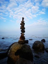 Stack of stones on beach against sky