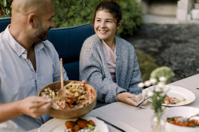 Midsection of woman holding food while sitting on table