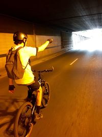 Man riding motorcycle on illuminated street at night