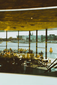 View of restaurant by sea seen through glass window