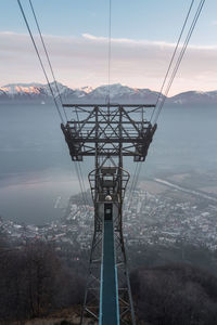 Low angle view of overhead cable car against sky