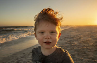 Portrait of boy at beach during sunset