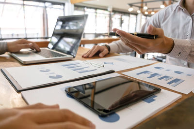 Close-up of woman using laptop on table