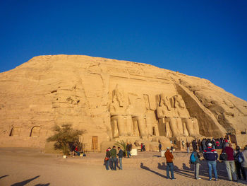 Tourist visiting temple against clear blue sky