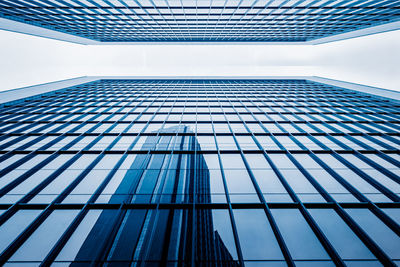 Directly below shot of modern building against blue sky