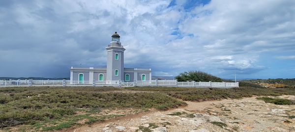 Lighthouse by sea against sky