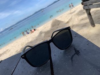 Close-up of sunglasses on beach